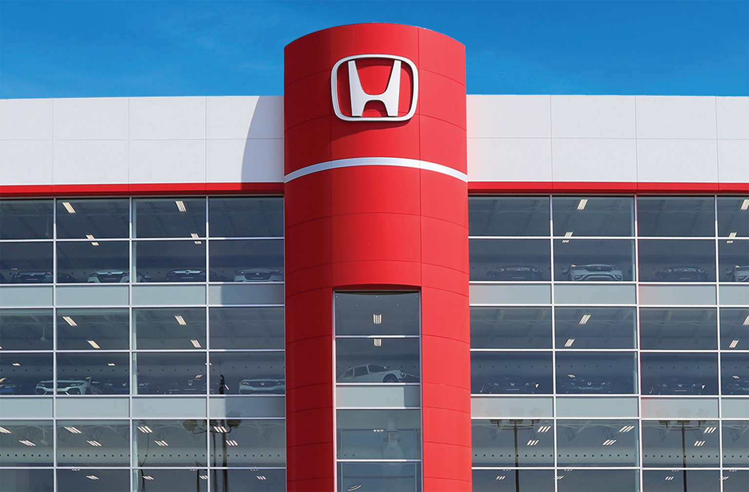 Un véhicule neuf devant un concessionnaire Honda.