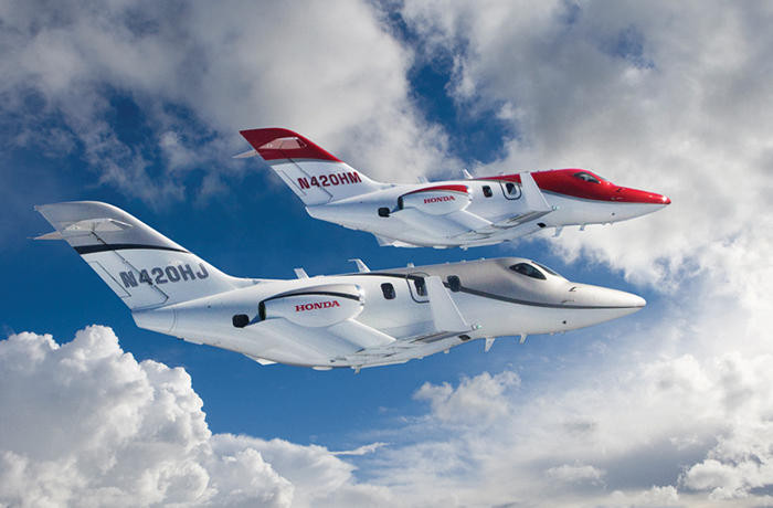 Image de HondaJet rouge et gris volant dans le ciel.